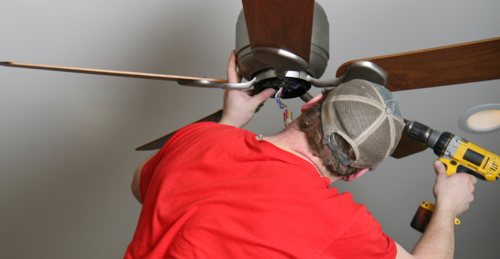 Technician installing ceiling fan